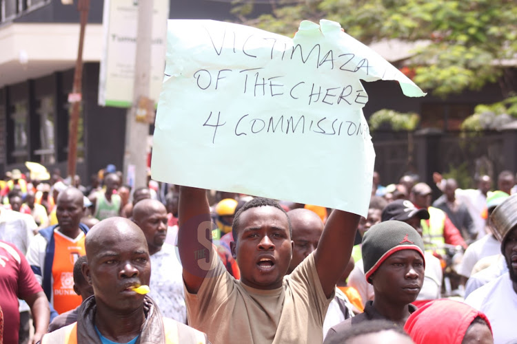 Protesters hold placards during demonstrations in Kisumu on March 10.  Image: DANIEL OGENDO